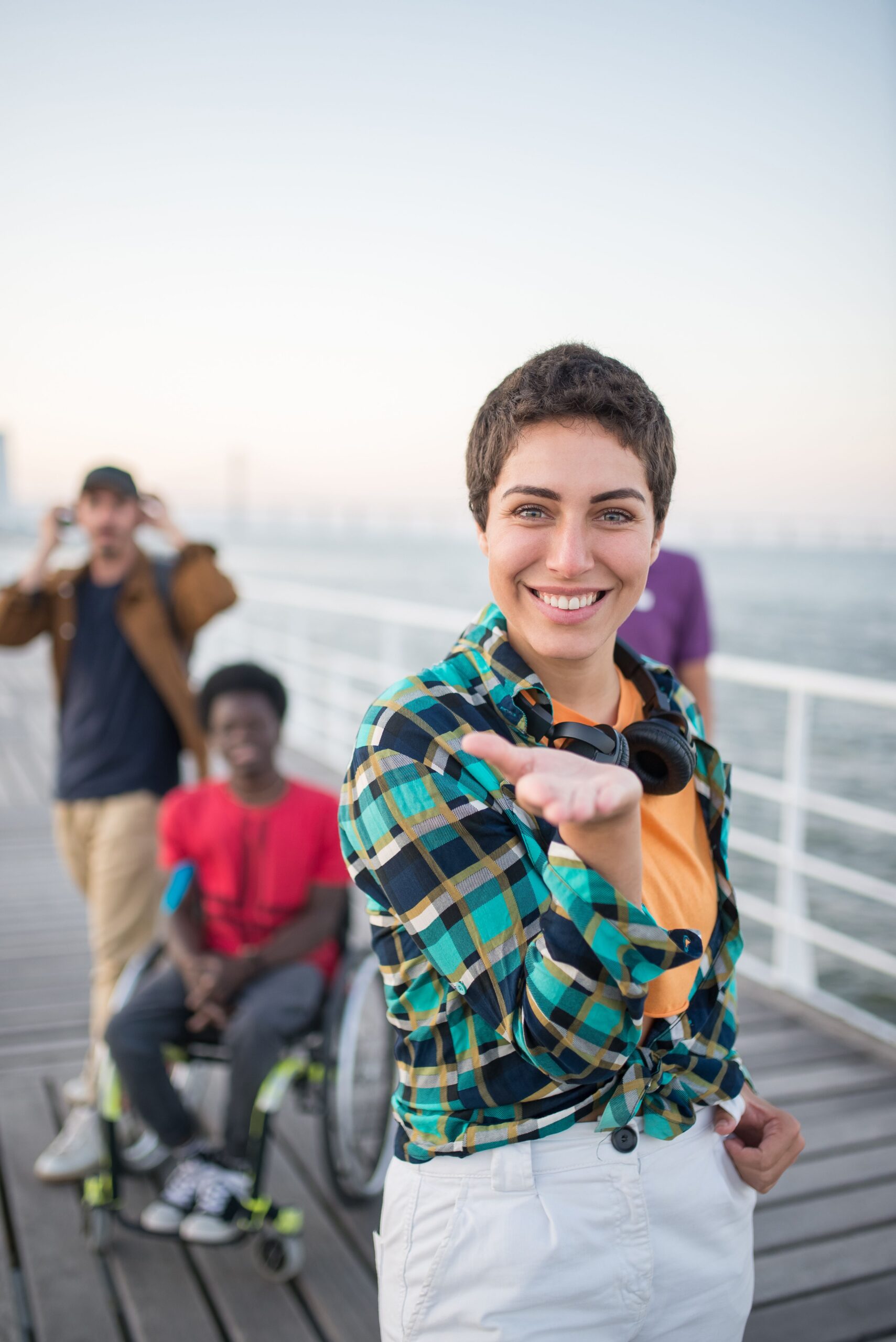 Three friends enjoying a day on a waterfront boardwalk, embodying a spirit of inclusivity and happiness.